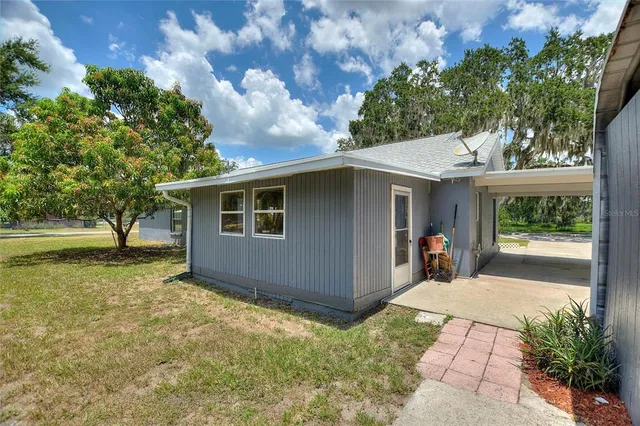 a backyard of a house with yard and outdoor seating