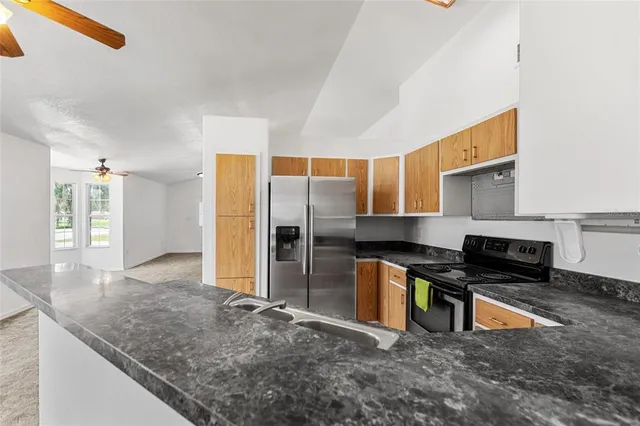 a kitchen with stainless steel appliances granite countertop a stove a sink and a refrigerator