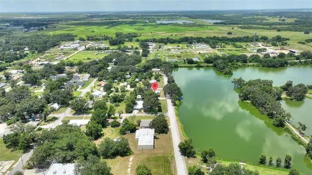 an aerial view of residential houses with outdoor space and lake view