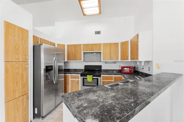 a kitchen with stainless steel appliances granite countertop a sink stove and refrigerator