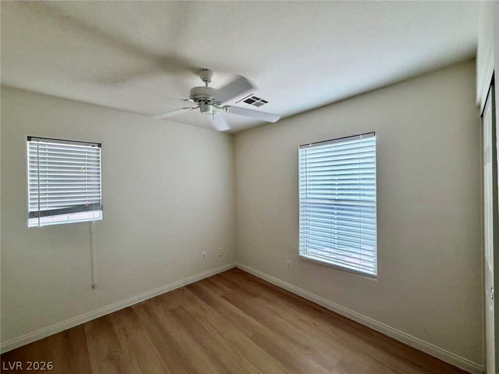 11183 Ranch Valley Street Las Vegas, NV 89179 - Photo 13 of 19 Well-lit interior space with sleek hardwood-style flooring and a functional ceiling fan.