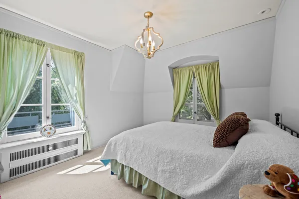 a bedroom with a bed and a large window