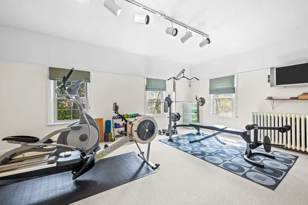 a living room with furniture gym equipment and a fireplace