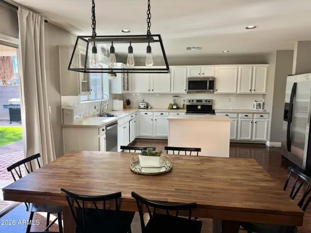 a view of kitchen with sink dining table and chairs