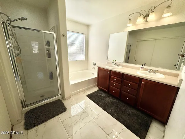 a spacious bathroom with a double vanity sink toilet mirror and shower