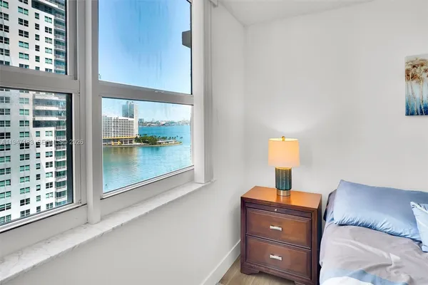 a room with a bed and a lamp on dresser