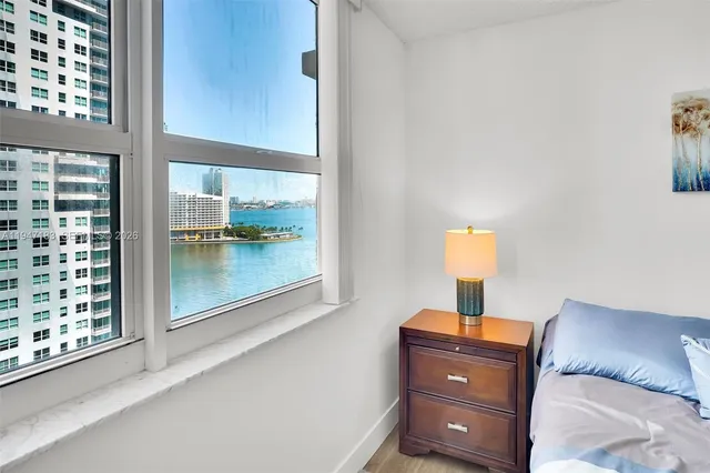 a room with a bed and a lamp on dresser