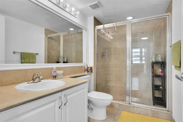 a bathroom with a sink vanity granite shower and a mirror