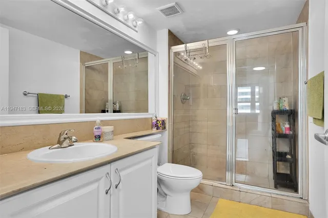 a bathroom with a sink vanity granite shower and a mirror