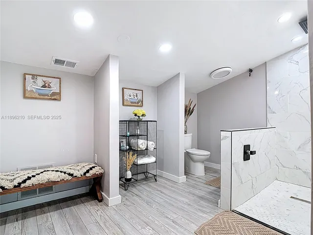 a bathroom with a toilet and a shower