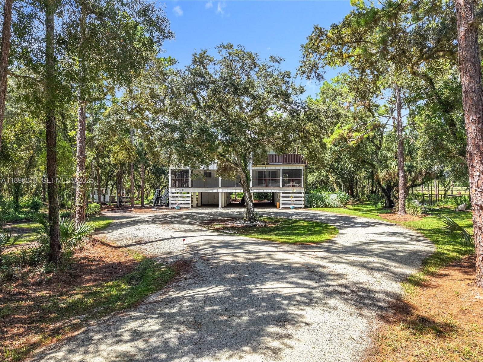 1270 Tom Coker Road LaBelle, FL 33935 - Photo 43 of 46 a view of a house with backyard and trees