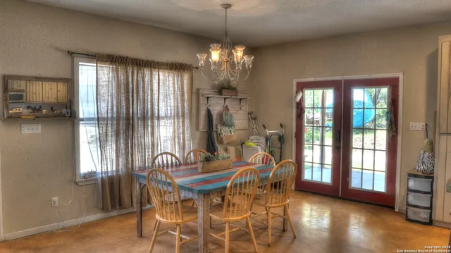 a kitchen with stainless steel appliances granite countertop a dining table and chairs