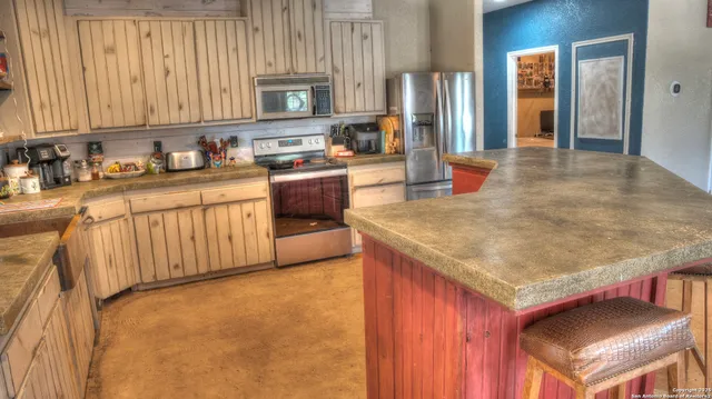 a kitchen with kitchen island granite countertop wooden cabinets a oven and a sink