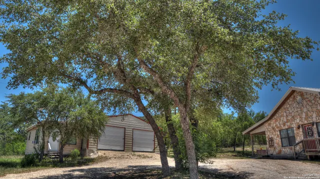 a front view of a house with a yard and tree
