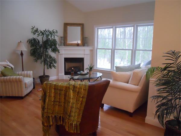 26 Sanctuary Lane, Unit 26 Hopkinton, MA 01748 - Photo 4 of 10 a living room with furniture a large window and a fireplace