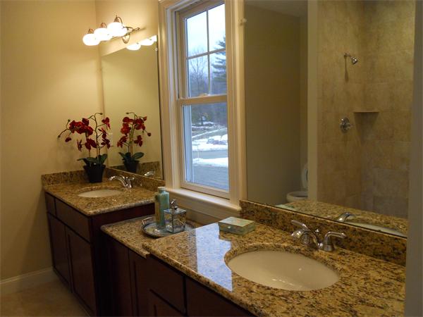 26 Sanctuary Lane, Unit 26 Hopkinton, MA 01748 - Photo 9 of 10 a bathroom with a granite countertop sink a large mirror and a shower