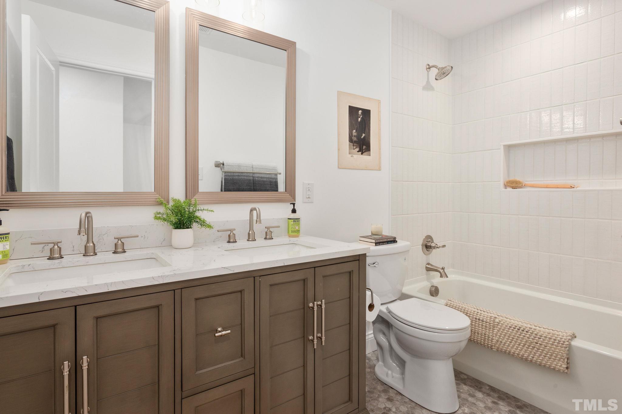 311 Lord Ashley Road Raleigh, NC 27610 - Photo 22 of 39 a bathroom with a toilet a sink a tub and a mirror