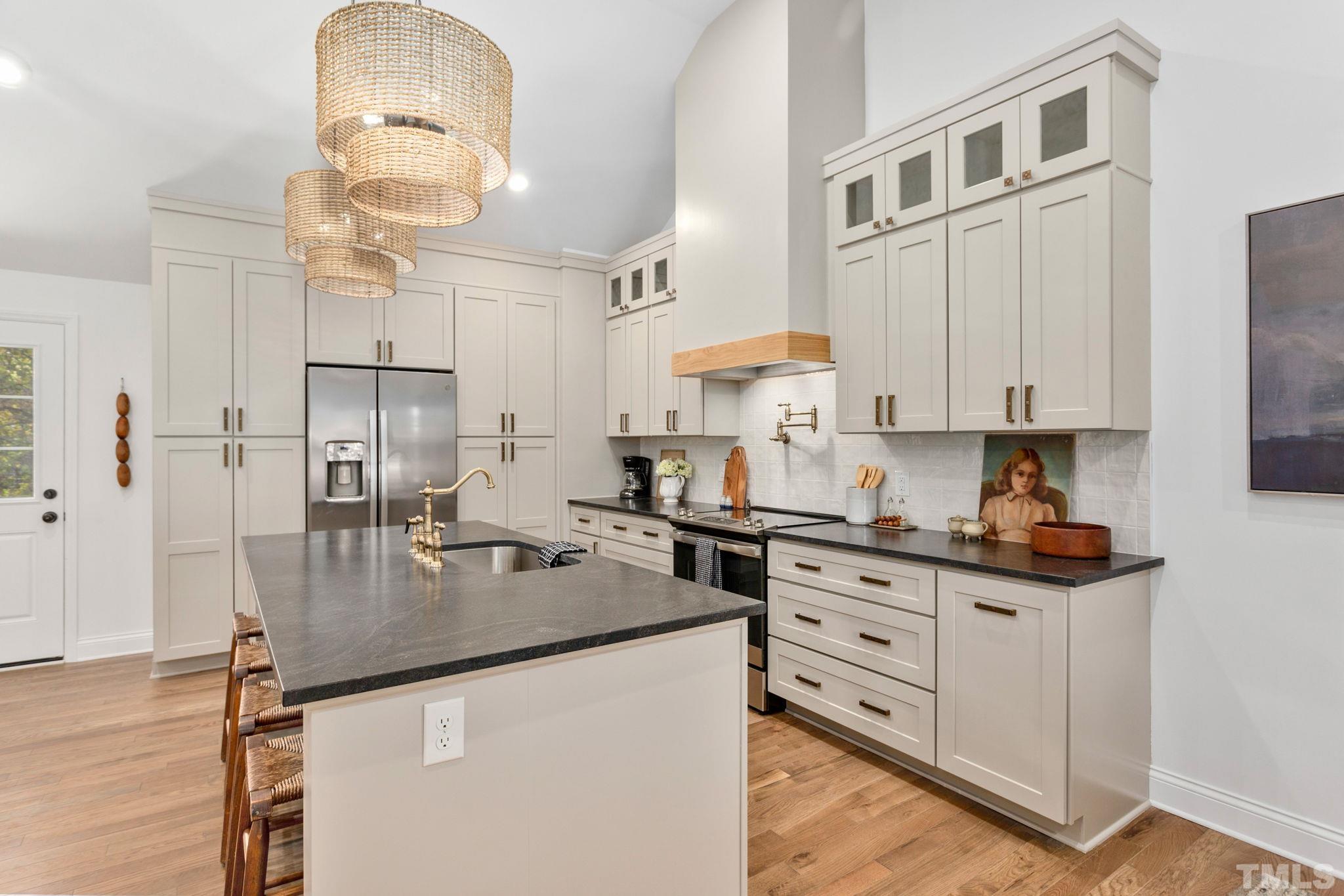 311 Lord Ashley Road Raleigh, NC 27610 - Photo 7 of 39 a kitchen with stainless steel appliances granite countertop a sink a stove and cabinets
