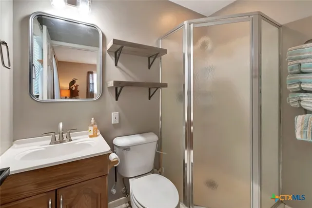 a bathroom with a toilet a sink and glass door