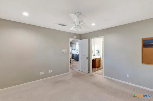 an empty room with fan and windows