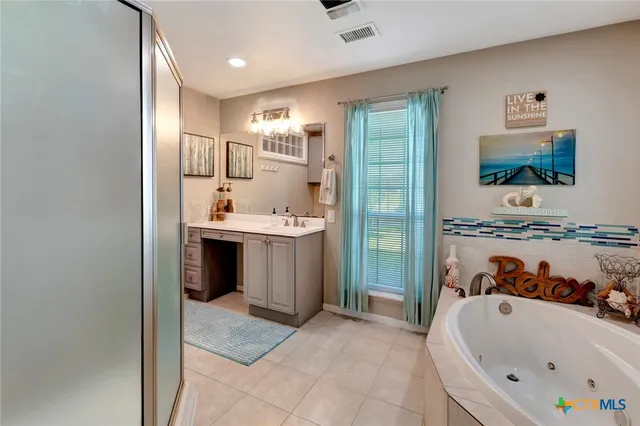 a bathroom with a tub a sink and mirror
