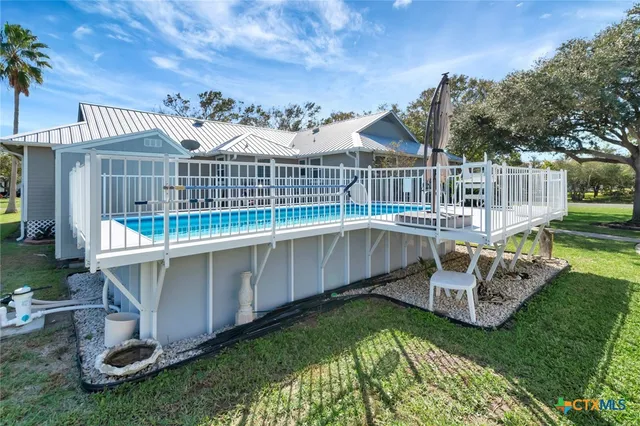 a view of a house with a wooden deck and a garden