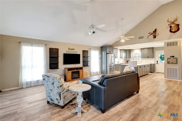 a living room with furniture a flat screen tv and kitchen view