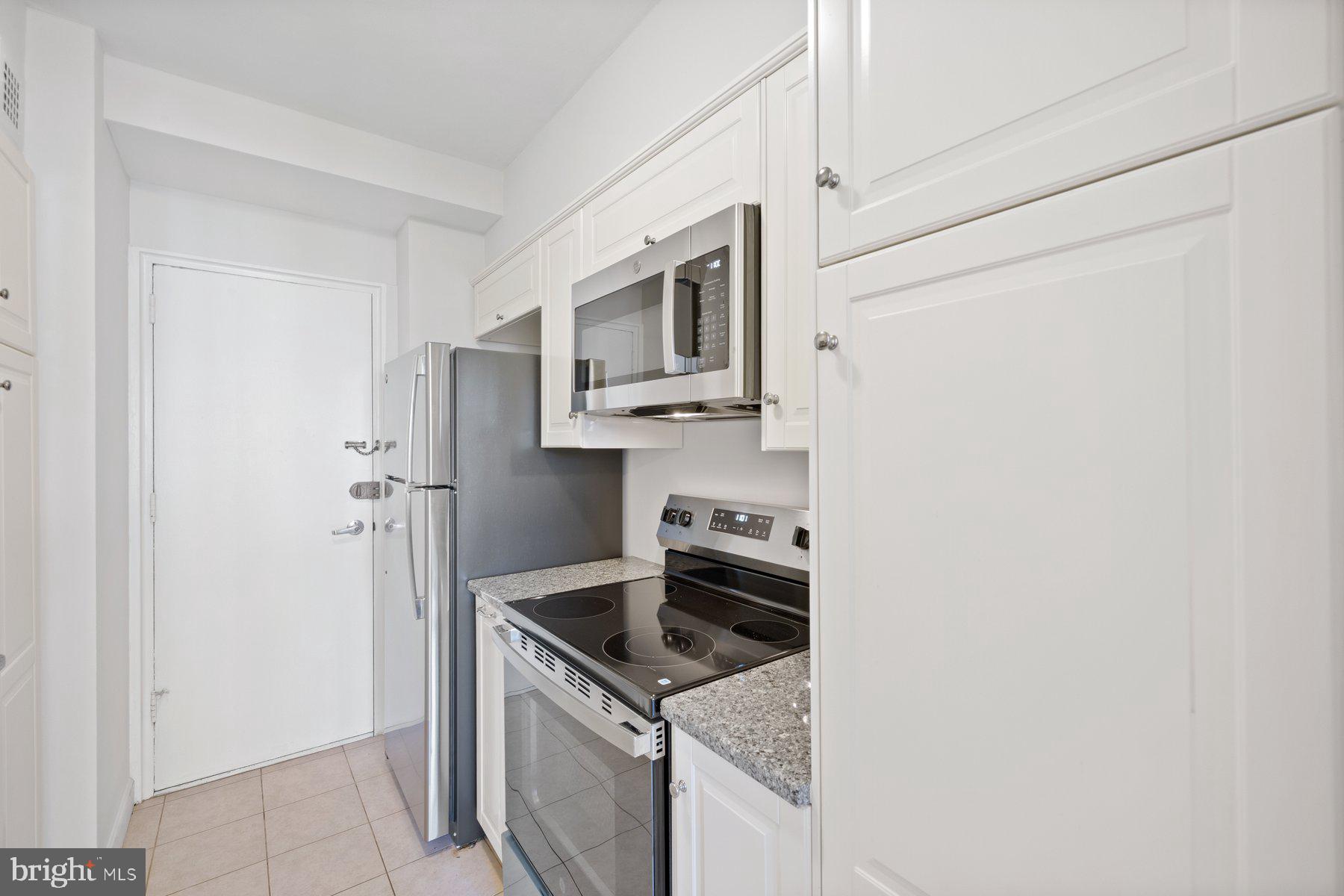 4740 Connecticut Avenue Northwest, Unit 804 Washington, DC 20008 - Photo 11 of 25 a kitchen with granite countertop a sink stove and refrigerator