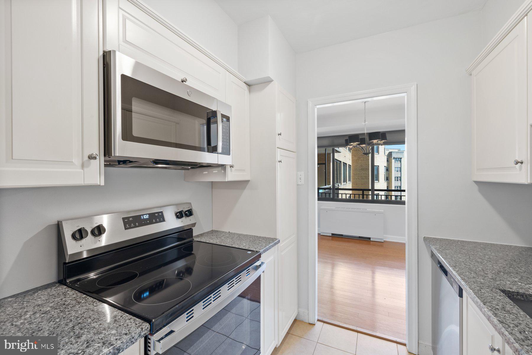 4740 Connecticut Avenue Northwest, Unit 804 Washington, DC 20008 - Photo 13 of 25 a kitchen with stainless steel appliances granite countertop a stove and a microwave