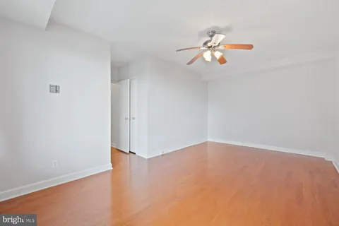 an empty room with a window and ceiling fan