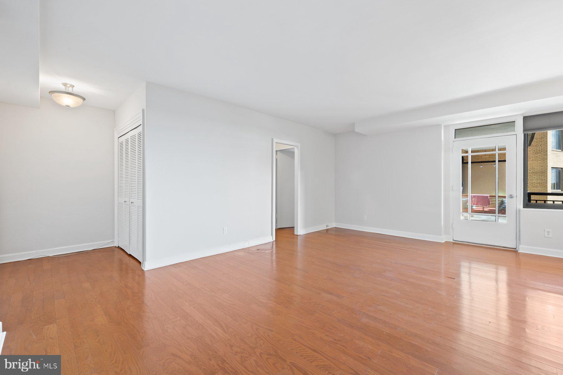 4740 Connecticut Avenue Northwest, Unit 804 Washington, DC 20008 - Photo 5 of 25 a view of an empty room with wooden floor and a window