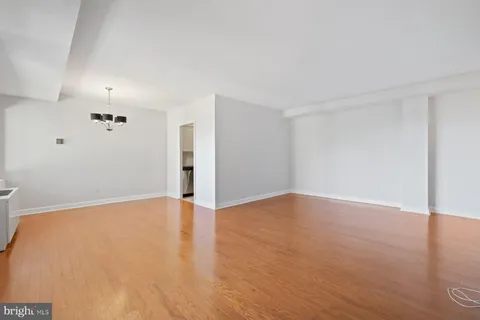 a view of an empty room with wooden floor