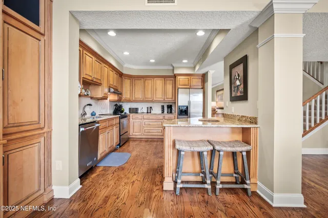 a large kitchen with stainless steel appliances granite countertop a stove refrigerator sink and cabinets