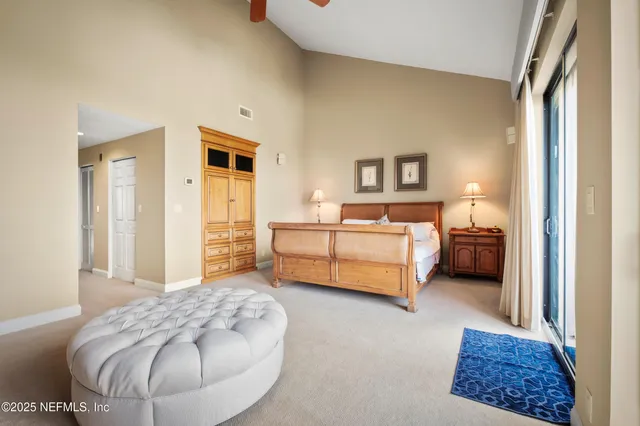 a bedroom with a large bed a flat tv screen and dresser