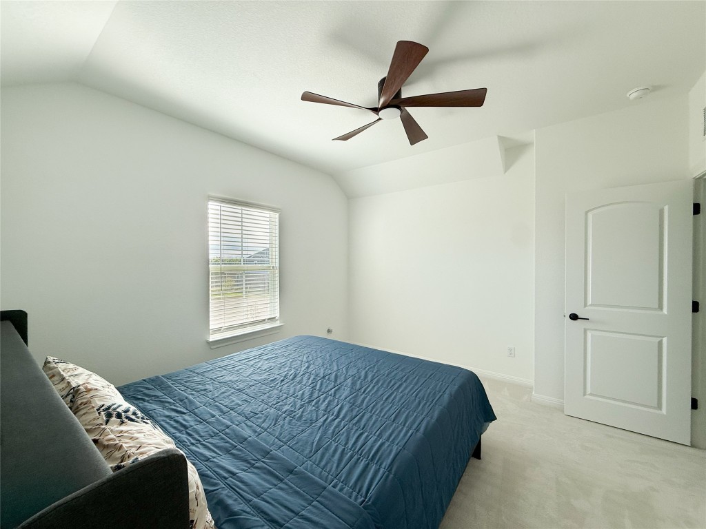253 Inlet Lane Leander, TX 78641 - Photo 16 of 23 Bedroom featuring light carpet, vaulted ceiling, and ceiling fan