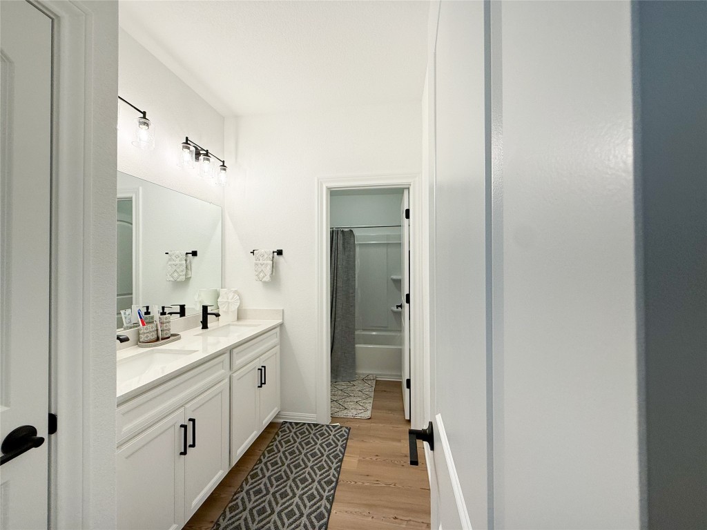 253 Inlet Lane Leander, TX 78641 - Photo 17 of 23 Full bath featuring double vanity, shower / bath combo, and light wood-style floors