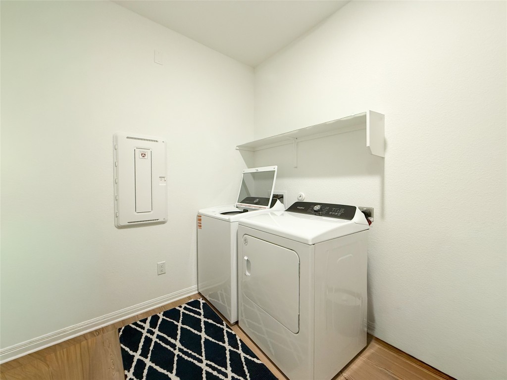 253 Inlet Lane Leander, TX 78641 - Photo 21 of 23 Washroom featuring electric panel, washer and dryer, and light wood-style floors