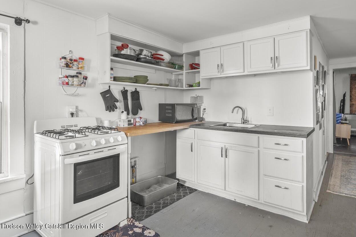 543 State Street, Unit 2 Hudson, NY 12534 - Photo 19 of 22 a kitchen with white cabinets and appliances