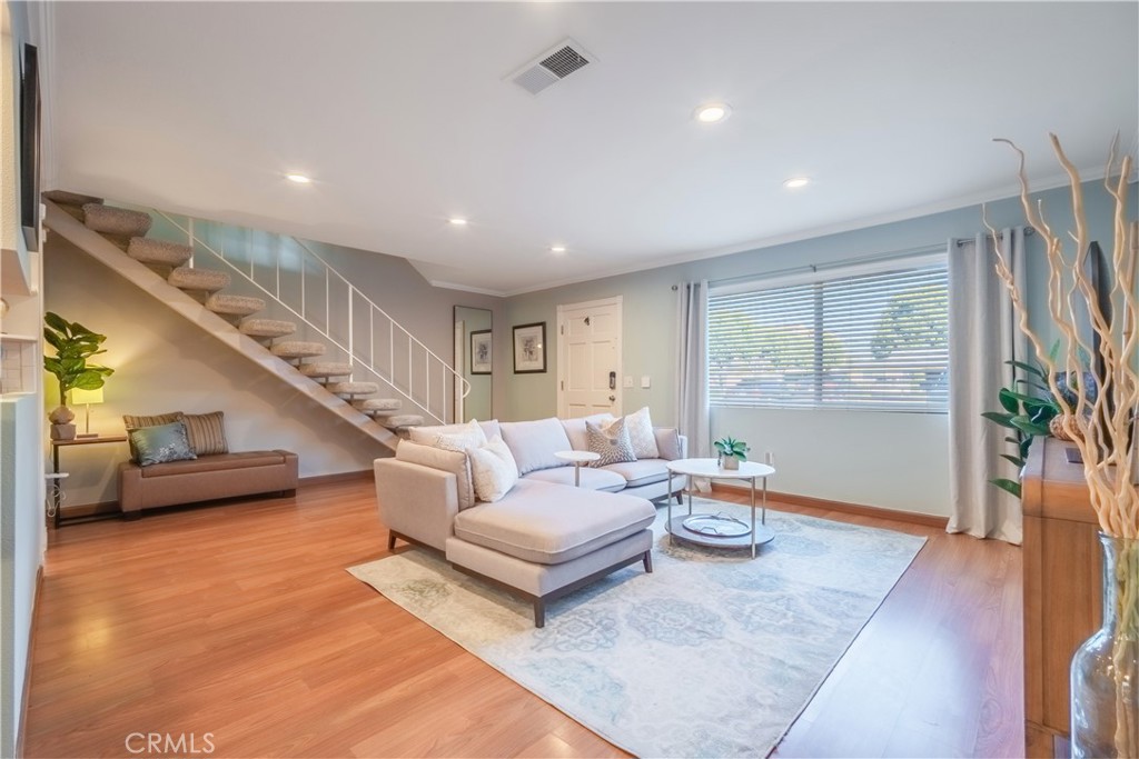 a living room with furniture and a wooden floor