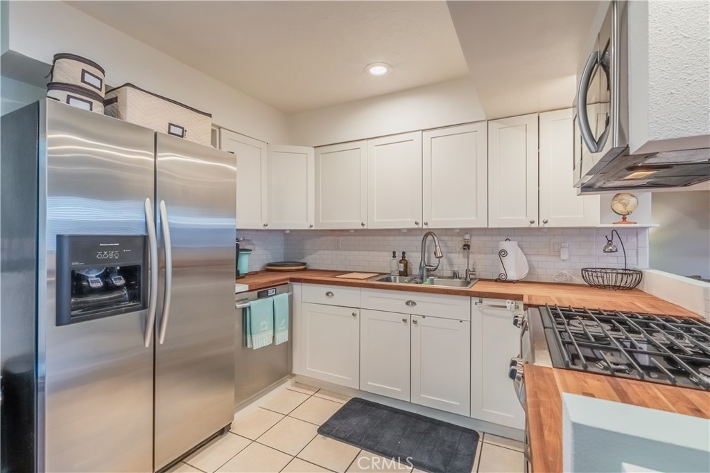 630 South Knott, Unit 14 Anaheim, CA 92804 - Photo 9 of 26 a kitchen with stainless steel appliances granite countertop a refrigerator a sink and white cabinets
