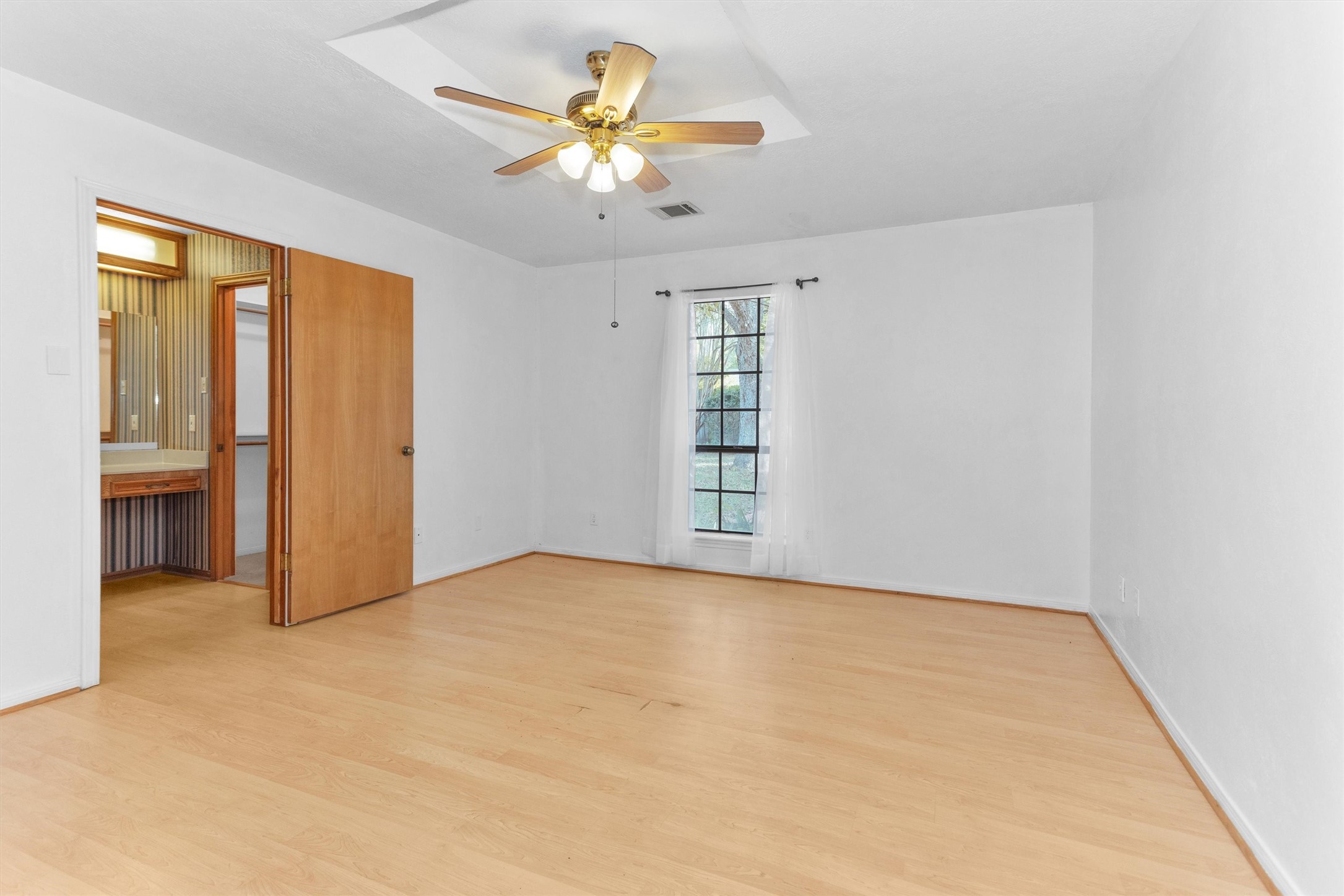 1706 Shawnee Street Navasota, TX 77868 - Photo 13 of 29 an empty room with a chandelier fan and windows