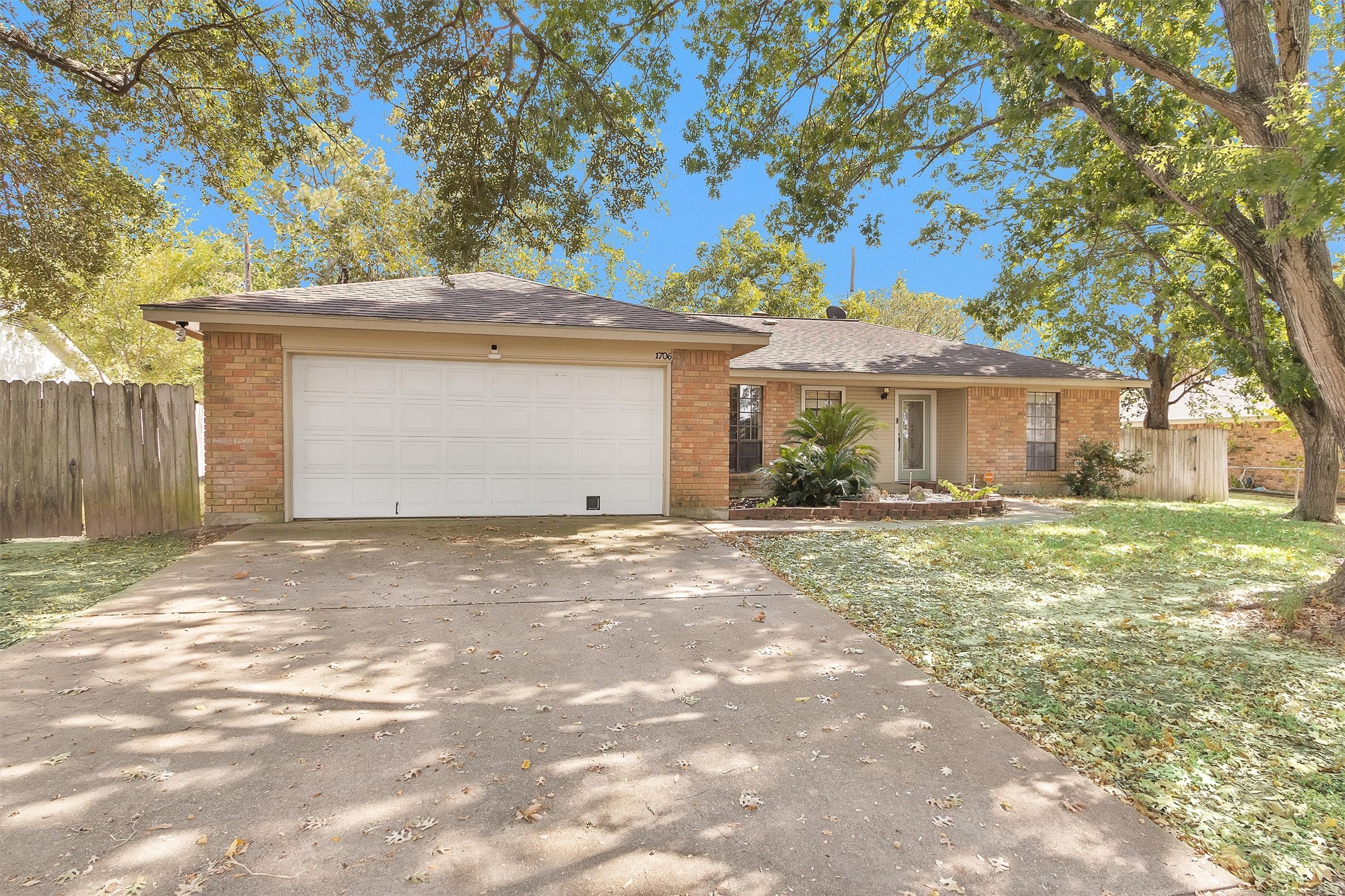 1706 Shawnee Street Navasota, TX 77868 - Photo 2 of 29 a front view of a house with a yard and garage