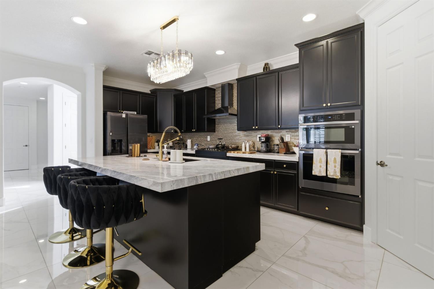 243 John Kamps Way Ripon, CA 95366 - Photo 24 of 62 a kitchen with kitchen island granite countertop a sink refrigerator and cabinets