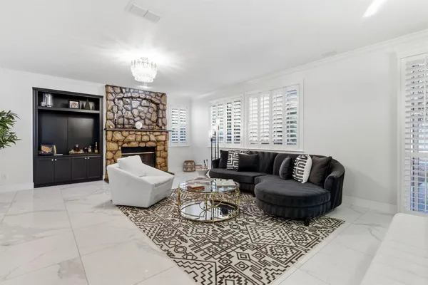 a living room with furniture a chandelier and a window