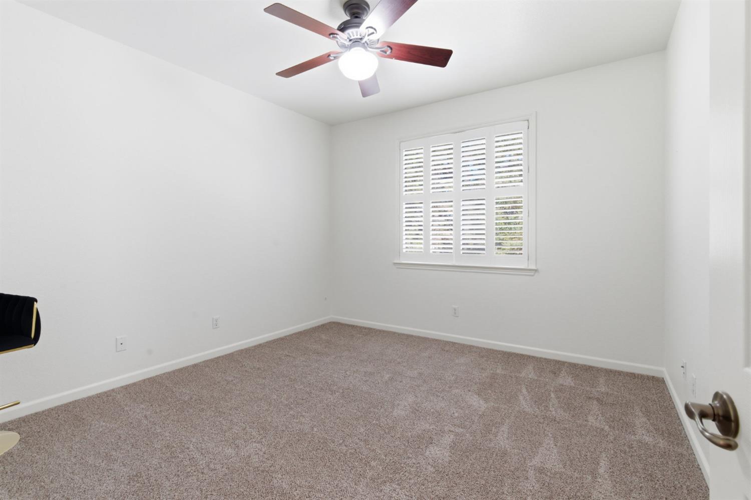 243 John Kamps Way Ripon, CA 95366 - Photo 38 of 62 an empty room with a window and a fan