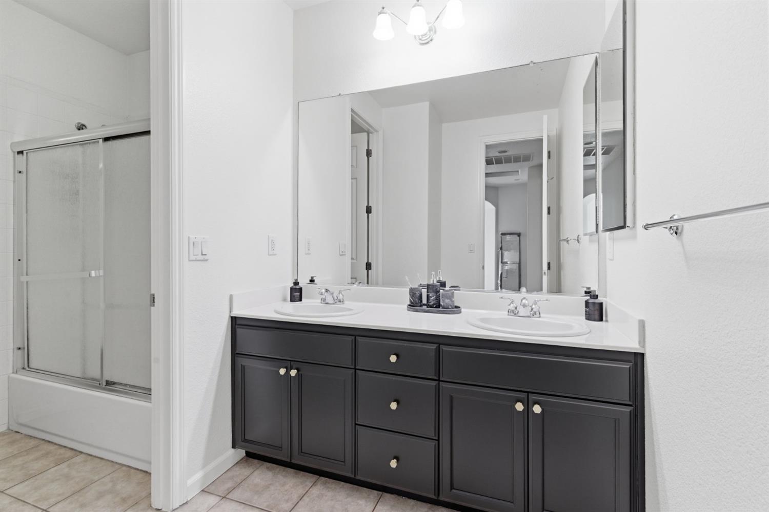 243 John Kamps Way Ripon, CA 95366 - Photo 39 of 62 a bathroom with a double vanity sink and mirror