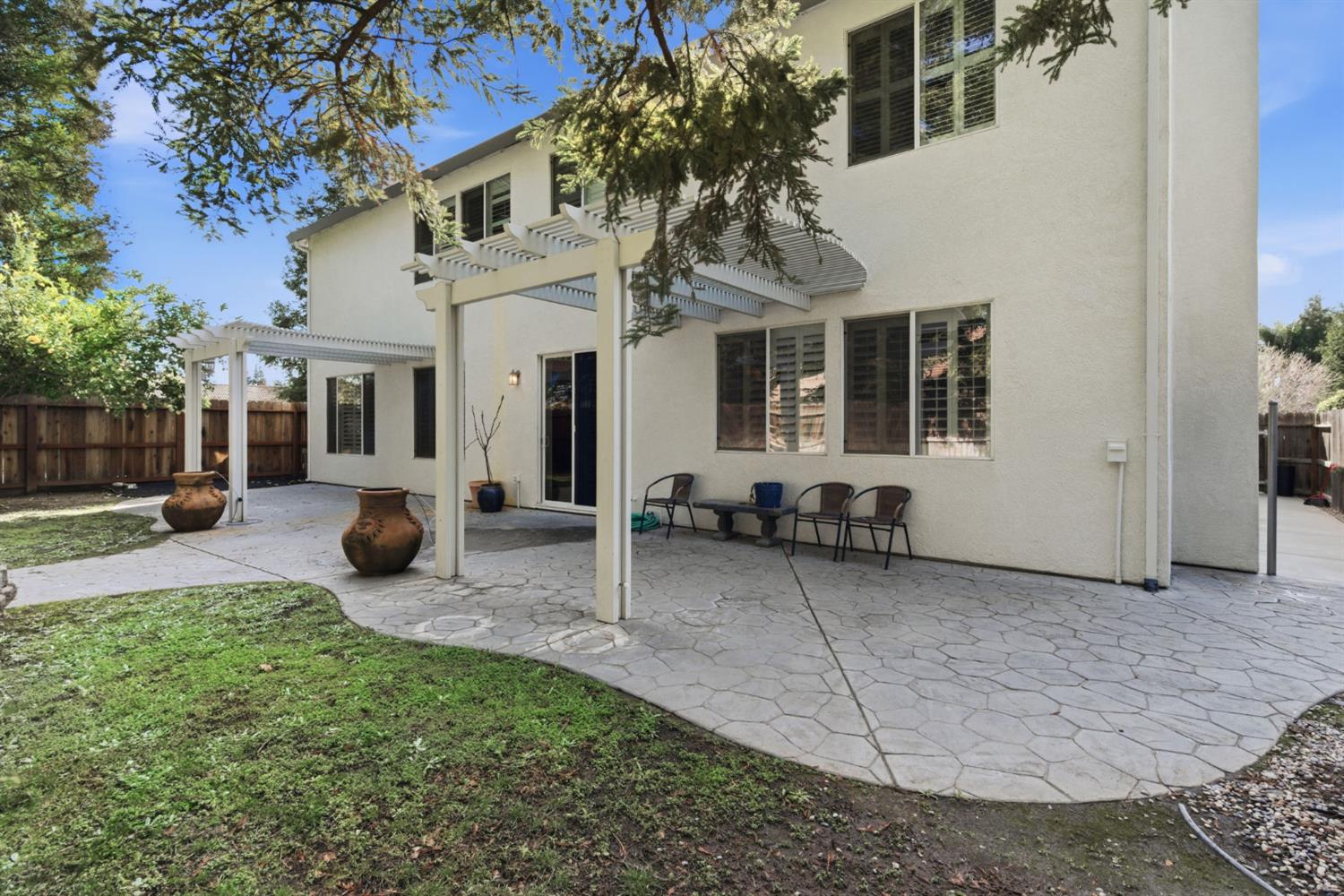 243 John Kamps Way Ripon, CA 95366 - Photo 49 of 62 a view of a white house with large windows and a yard