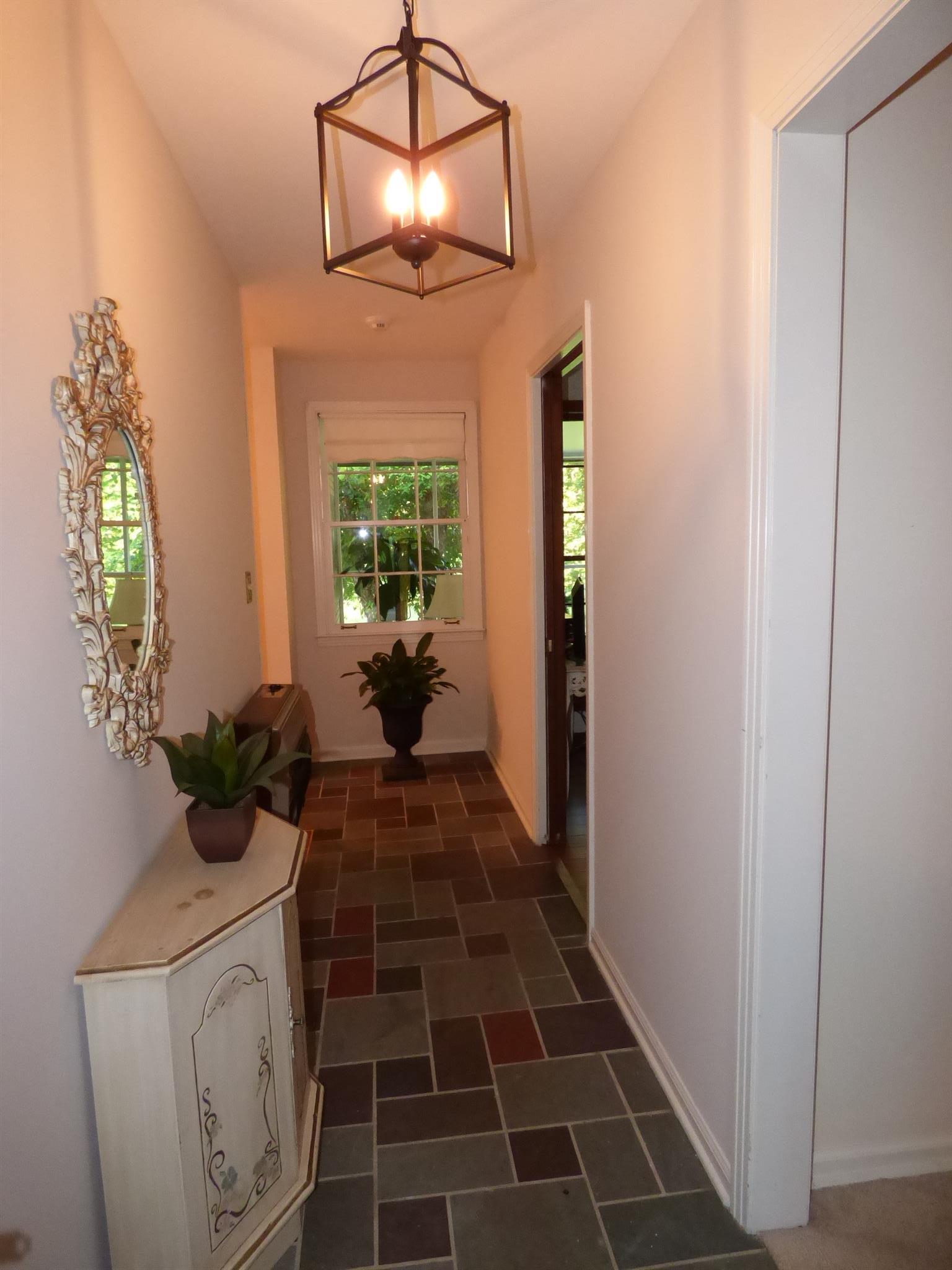 441 Excell Road Clarksville, TN 37043 - Photo 2 of 30 a view of a hallway with wooden floor and a chandelier