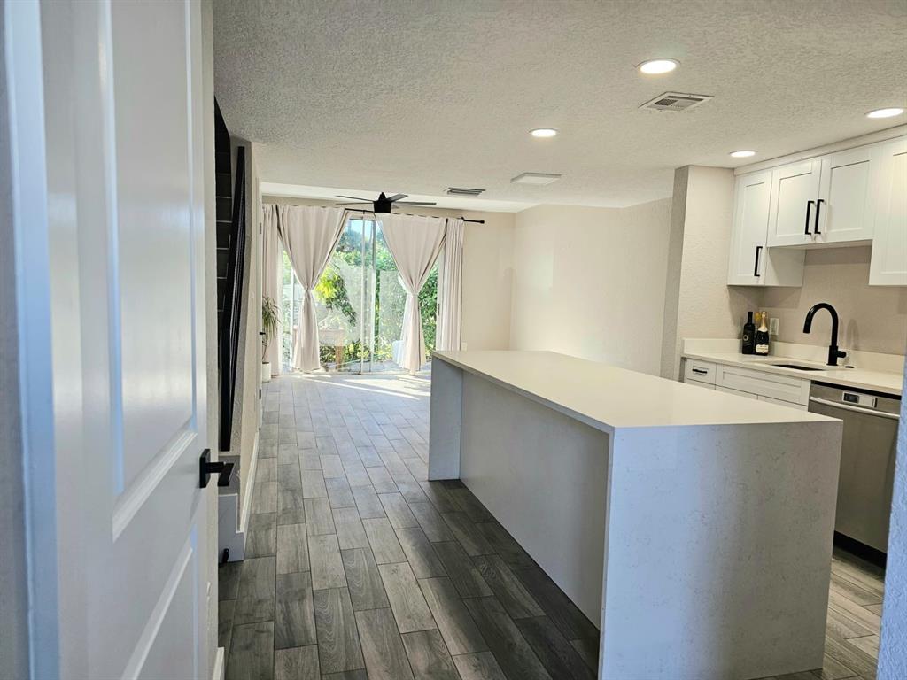 1102 Jeffery Street Boca Raton, FL 33487 - Photo 2 of 14 a kitchen with kitchen island a counter top space a sink and cabinets