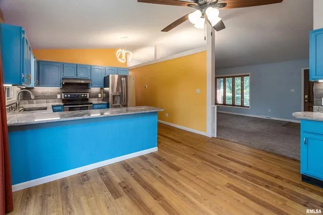 a kitchen with granite countertop a stove cabinets and wooden floor